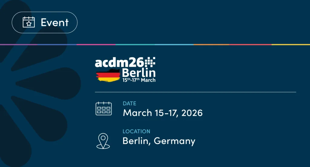 Graphic announcing the ACDM26 Berlin event featuring uMotif branding. The top left includes a rounded rectangular button labeled Event with a calendar icon. Centered is the ACDM26 Berlin logo with a stylized German flag graphic and the text 15th–17th March. Below, event details list the date as March 15–17, 2026, and the location as Berlin, Germany. The background is dark teal with abstract petal-like shapes and a thin multicolor line across the top.